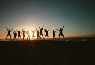 silhouette photography of group of people jumping during golden time