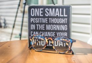 photo of a sign and eyeglasses on table