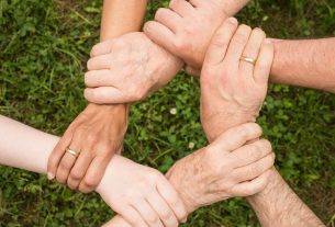 group of people holding arms