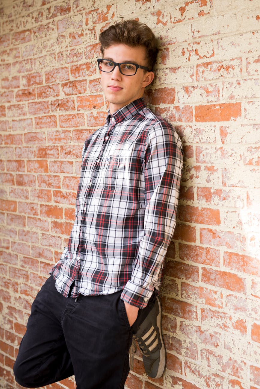 man wearing plaid dress shirt and black pants