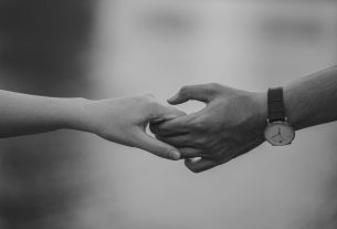 monochrome photo of couple holding hands